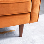 Close-up of an orange upholstered chair corner with a tapered dark wood leg on a light gray rug.
