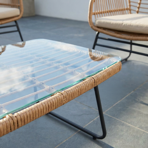 Wicker coffee table with glass top on a patio