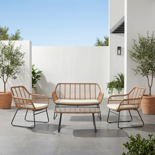 Outdoor patio set with wicker chairs and sofa on a modern patio with plants and white walls.