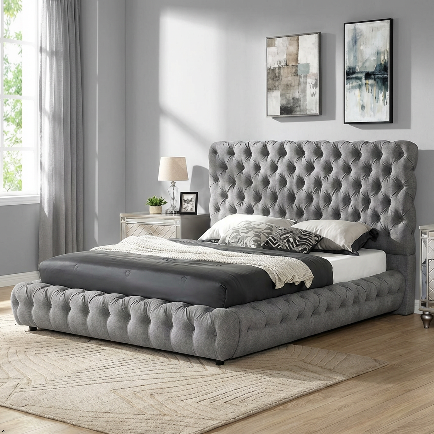 Gray tufted bed in a bedroom with abstract art on the wall.