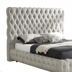 Gray tufted bed with white bedding and decorative pillows on a white background
