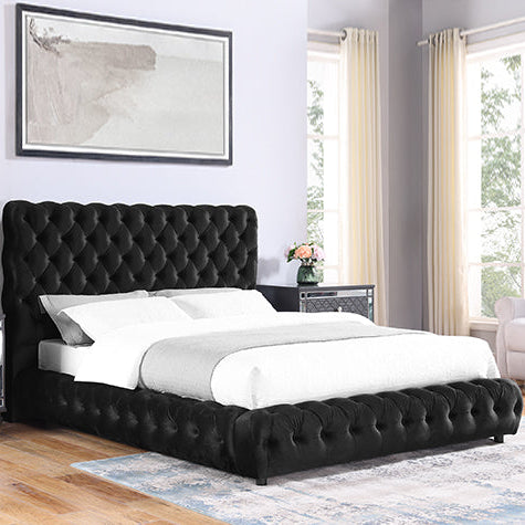 Black tufted bed in a bedroom with white bedding and decorative elements.