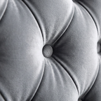Close-up of a tufted gray cushion with a button detail