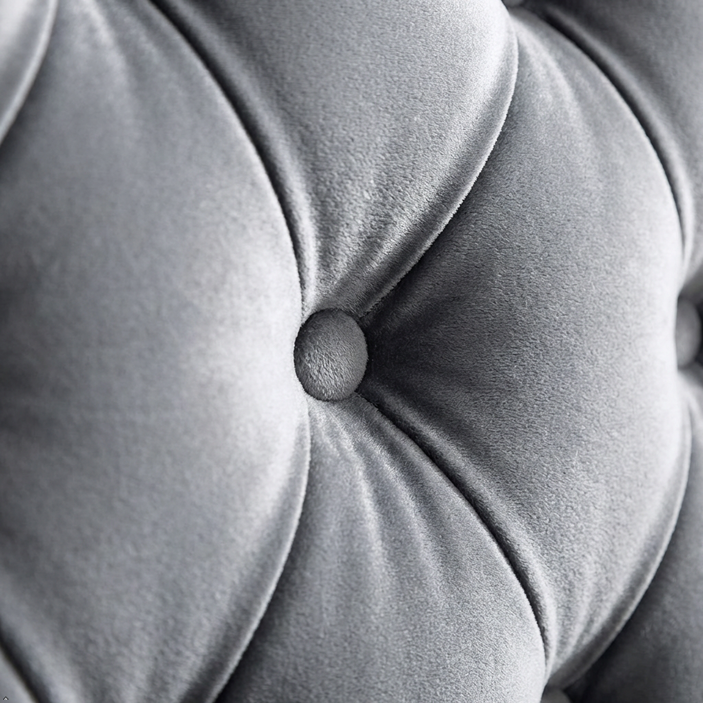 Close-up of a tufted gray cushion with a button detail
