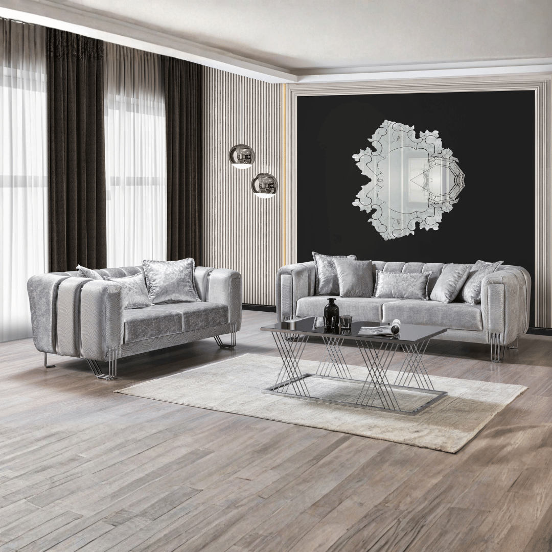 Modern living room with gray sofas, a glass coffee table, and decorative mirror on the wall.