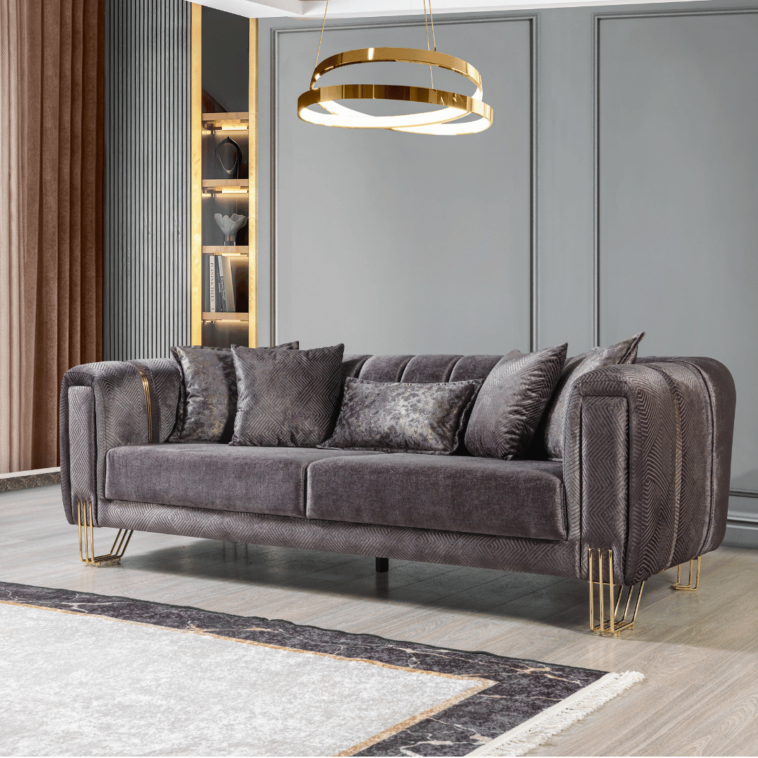 Gray velvet sofa with gold legs in a modern living room setting.