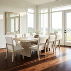 Dining room with a white table and chairs in a bright room with large windows.