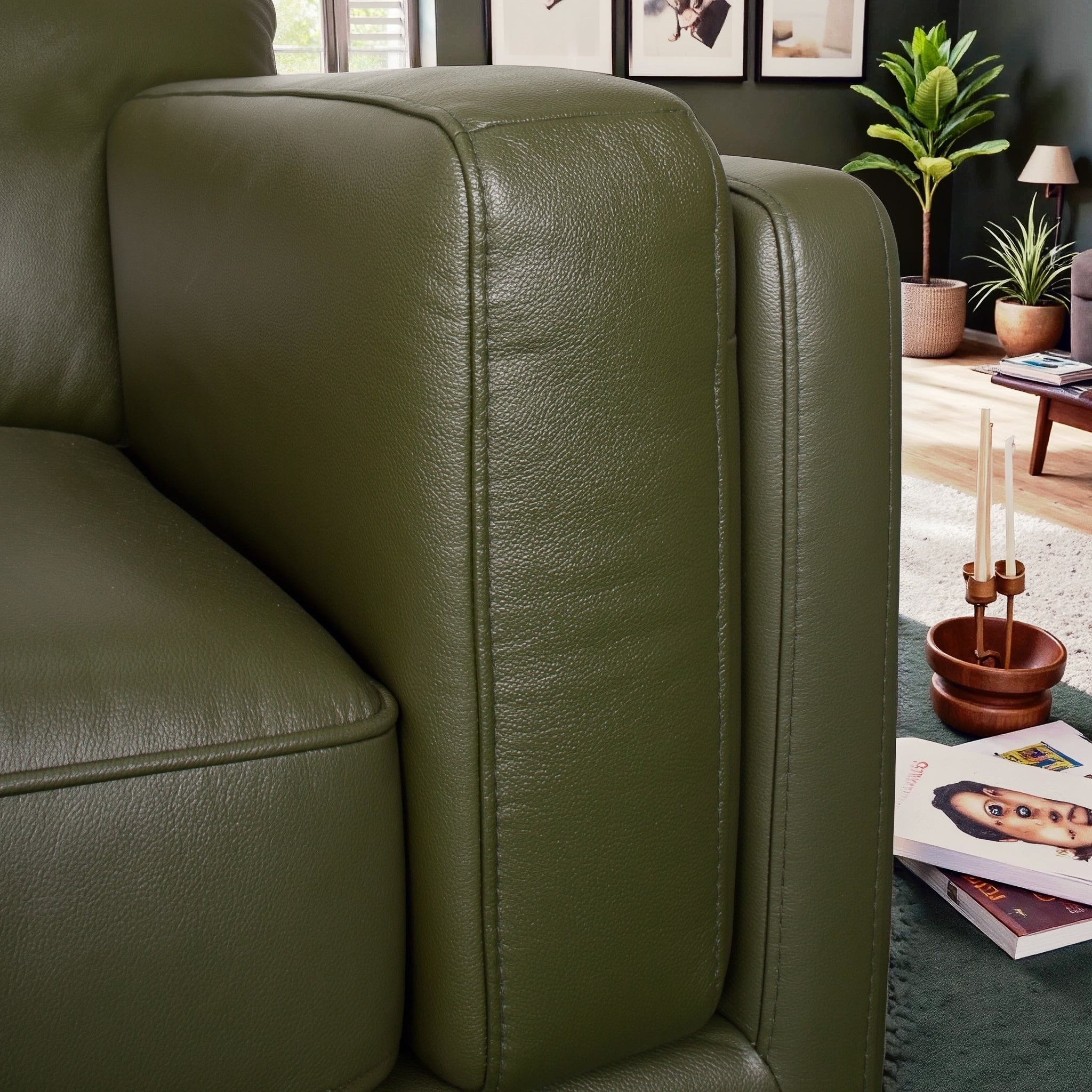 Green leather sofa in a living room setting with decor elements.