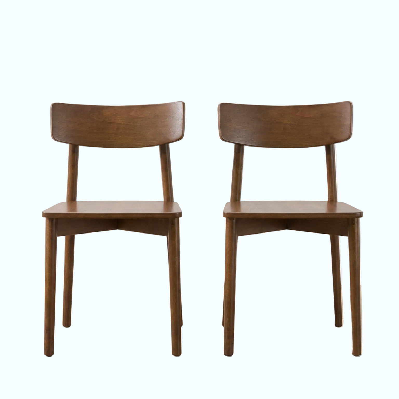 Two matching wooden dining chairs with curved backrests and angled legs, shown side by side on a light wood floor against a white wall.