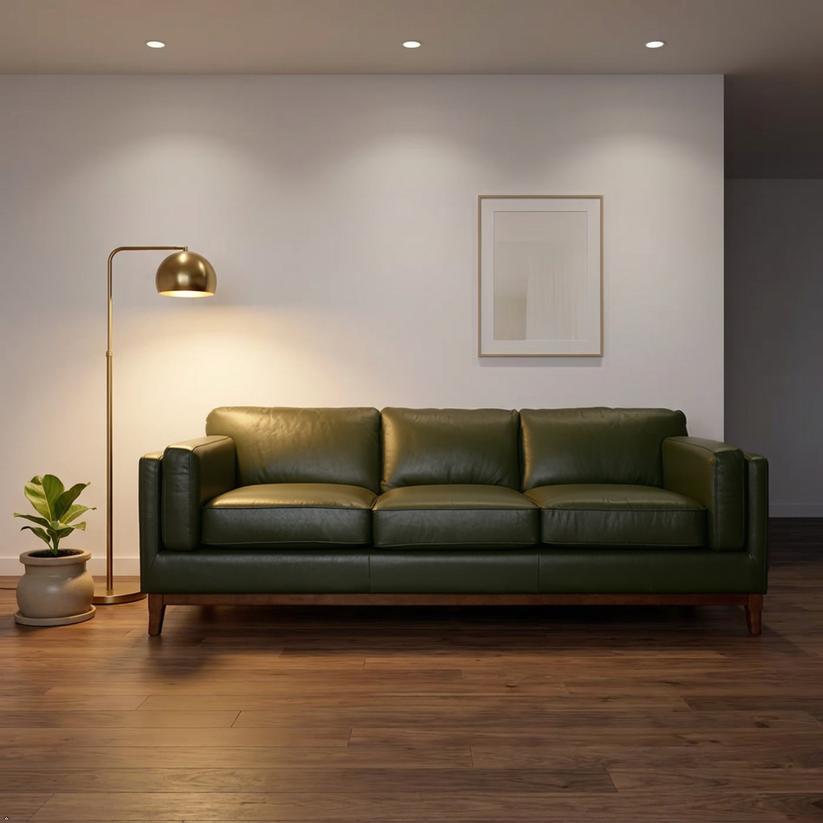 A three-seat olive green leather sofa in a modern living room setting with a gold floor lamp, wooden floor, and a minimalist framed print on the wall.